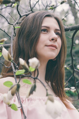 Closeup portrait of beautiful young woman in magnolia flowers. Spring girl with magnolia flowers....