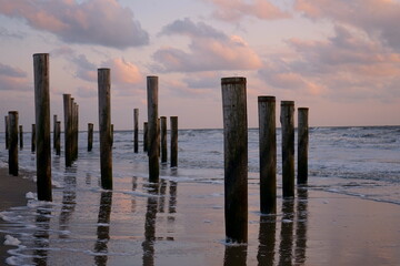 Fototapeta premium Buhnen in der Nordsee beim Abendrot
