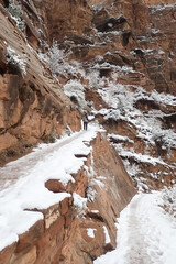 Hiker on snowy trail in winter at  Zion National Park, Utah