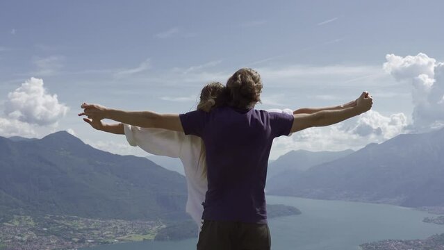 Two lovers embrace in front of the mountains