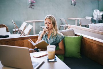 Skilled hipster girl with education notepad doing school homework and startup project, millennial...