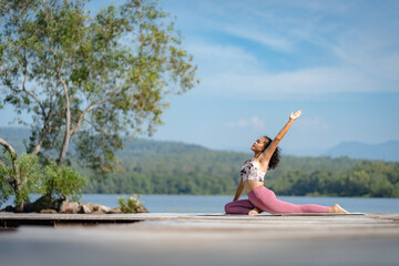 Fitness Asian woman doing yoga in park, Young woman practicing yoga, female happiness in landscape background, Lifestyle of exercise and pose for relax healthy life in the morning nature outdoor