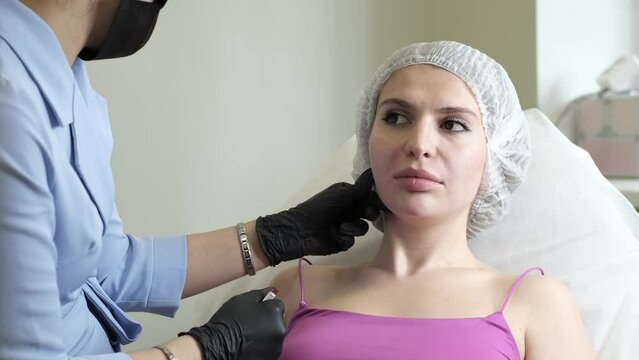 professional cosmetologist who probes the patient's skin, assessing its condition and the need for a tightening procedure