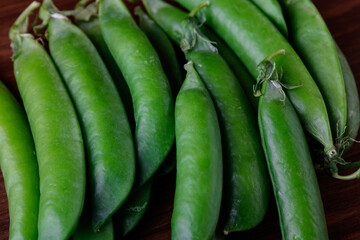 Green pea pods on wooden table. Ripe pea.