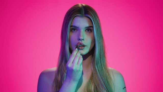 Nakładanie czerwonej szminki na usta 