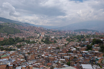 Fototapeta na wymiar Aerial panoramic view of poor neighborhoods and favelas built of red brick in city's outskirt. Comuna 13, Medellin, Colombia.