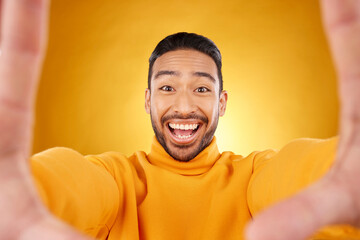 Excited, portrait and selfie of man in studio isolated on a yellow background. Face, smile and...