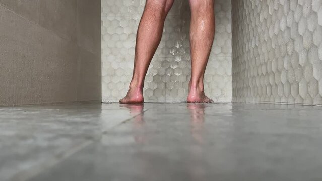 The man bathes in the shower. Man in the shower View of the legs.