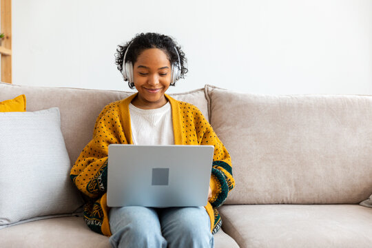 African American Girl Using Laptop At Home Office Looking At Screen Typing Chatting Reading Writing Email. Young Woman Having Virtual Meeting Online Chat Video Call Conference. Work Learning From Home