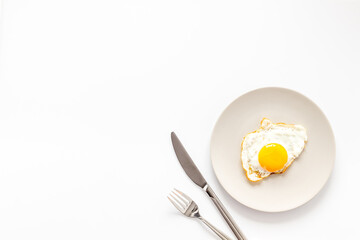 One fried egg on plate, top view. Breakfast background