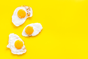 Fried eggs pattern on yellow background, top view. Breakfast concept