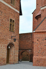 zdjęcie ceglanego wejścia do średniowiecznego zamku w Fromborku, Polska