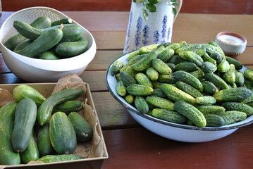 zdjęcie misy pełnej zielonych ogórków i cukinii leżących na stole