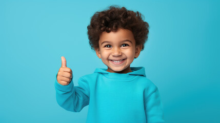 Boy wearing casual clothes standing over isolated blue background doing happy thumbs up gesture with hand.