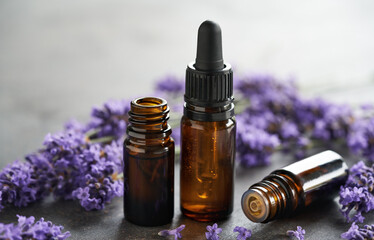 Bottles of aromatherapy essential oil with fresh lavender flowers