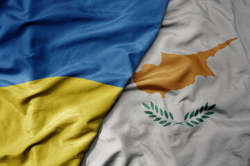 big waving national colorful flag of ukraine and national flag of cyprus .
