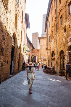 Fototapeta Beautiful female model on the old city streets of San Gimignano, Tuscany, Italy