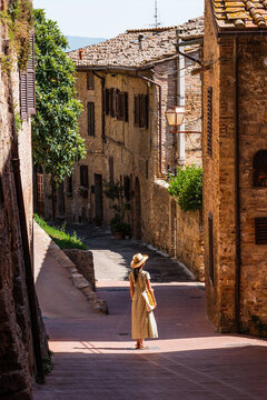 Fototapeta Beautiful female model on the old city streets of San Gimignano, Tuscany, Italy