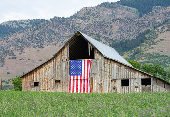 Patriotic American Flag hanging on old barn