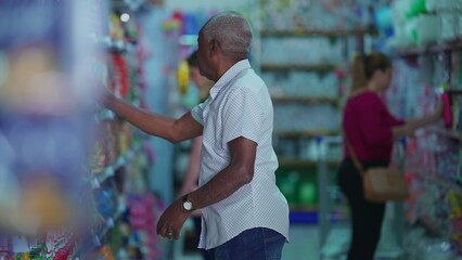 Customers shopping at grocery store aisle, Candid African American person searching for products