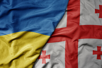 big waving national colorful flag of ukraine and national flag of georgia .