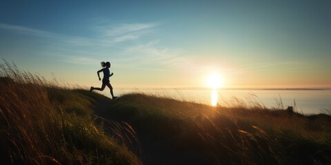 Fototapeta premium Energetic Silhouette of a Woman Running on Meadow Hill at Sunset, Enjoying the Coastal Beauty of Blue Sky, Ocean, and Shoreline in a Scenic Panoramic View, Embracing an Active and Healthy Lifestyle
