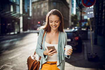 Young woman using a smart phone on a street in the city