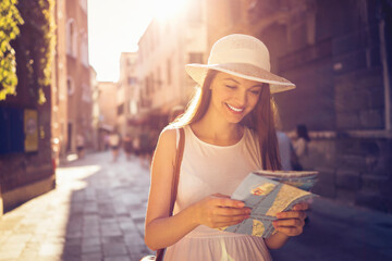 Young woman using the map to navigate the city while traveling