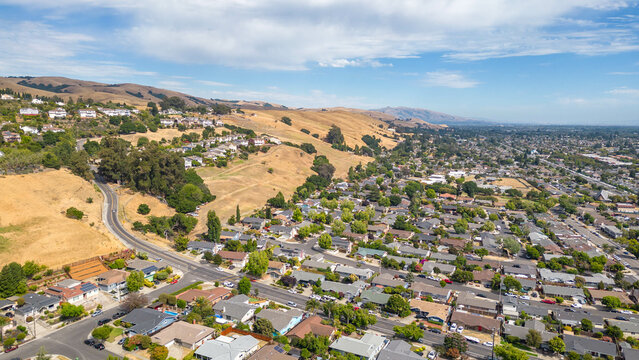 Aerial images over a neighborhood in Hayward, California with a blue sky and room for text.