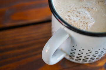 A cup of fresh coffee and a light mug on a wooden surface, table. View from above