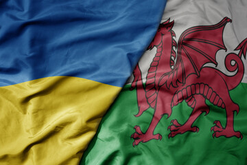 big waving national colorful flag of ukraine and national flag of wales .