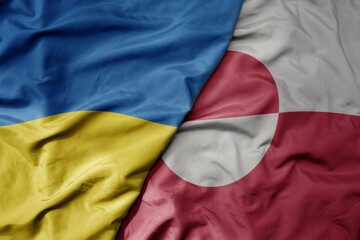 big waving national colorful flag of ukraine and national flag of greenland .