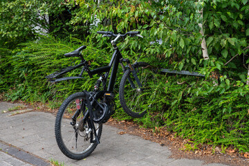 Fototapeta na wymiar Black bike parked on the edge of the footpath.