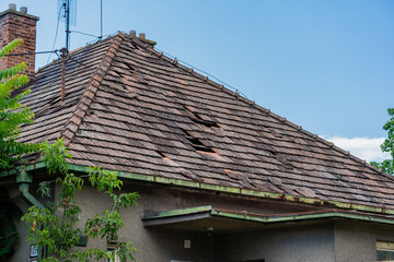 Damaged roof of an old rural house, Exceeded life expectancy, damaged by wind and rain, needs to be replaced. Storm damaged
