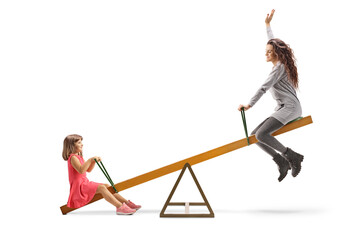 Child and a young woman playing on a seesaw