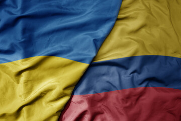 big waving national colorful flag of ukraine and national flag of colombia .