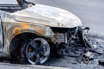 Fototapeta premium The car after the fire. Iron parts of a burnt car. Abandoned burnt-out car, due to a short circuit, arson.ready for scrapping