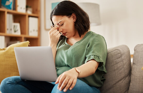 Woman, home and headache with burnout with laptop and remote work stress on sofa feeling frustrated. House, female person and confused from computer problem with anxiety from online website on couch