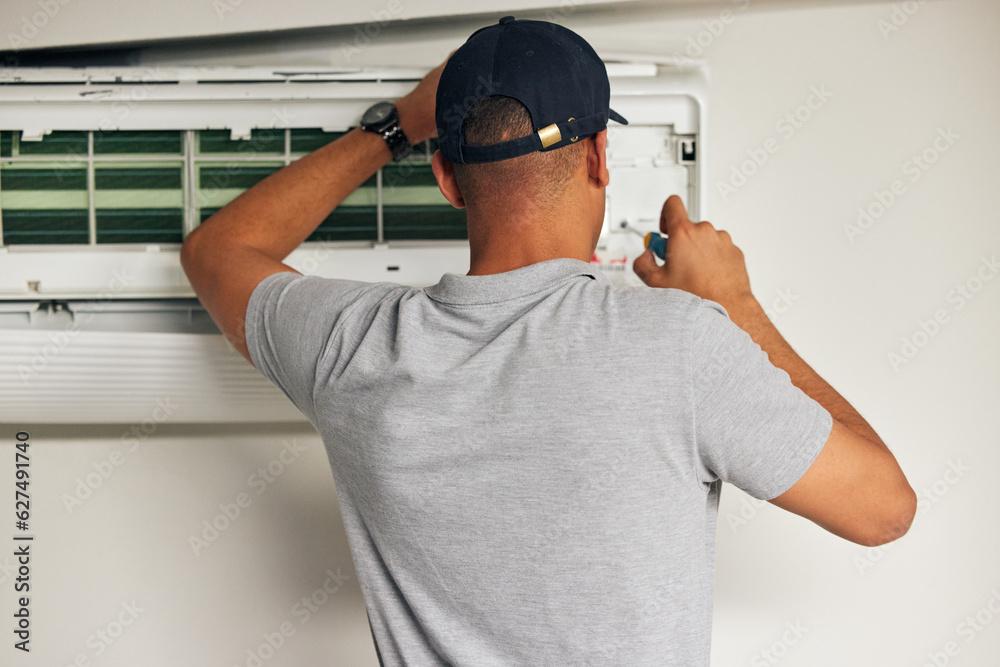 Poster Maintenance, air conditioner and man with screwdriver for problem solving on machine from back. Aircon, ac repair and handyman service with technician, electrician or contractor work on ventilation.