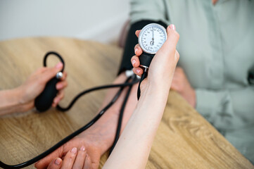 Checking blood pressure of senior patient with analog sphygmomanometer