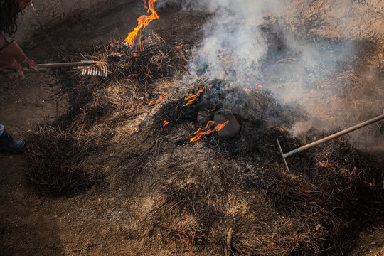 Final stage of uncovering the bonfire with the pieces of clay piled up during the cooking process of the black clay of Gondar in Amarante, Portugal.