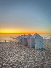Foto auf Acrylglas Nordeuropa View of furadouro beach at sunset with blue and white striped beach tents. Ovar, Aveiro, Portugal
