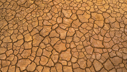 AERIAL TOP DOWN: Desiccated brown barren landscape with a cracked earth pattern