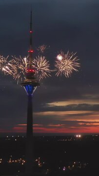 Tallinn.Estonia-August 20.2020: The orange sky of the Tallinn Estonia at night with the fireworks coming from the TV tower of the capital. Camera moves from left to right. Vertical shot.