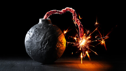 Round black bomb with lit fuse burning with sparks. Bomb about to detonate symbolizing destruction,...