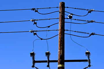 Fuse cutout, tension insulators and jump cables connecting electrical transmission lines are parts of the electrical grid infrastructure 