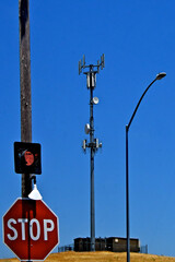 Rural intersection with “Stop Light”, a street light and cell tower to cover area between small towns, Central Valley, California. Isolated cell tower gets data from microwave backhaul 