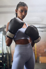Young indian woman, boxing gym and portrait in gloves for fight, training or workout for health....