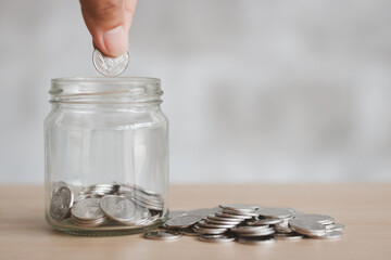 Saving finance business investment concept. Hand of male or female putting coins in jar with money stack step growing growth saving money. Investment And Interest Concept.