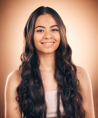 Face, curly hair and beauty of woman in studio isolated on a brown background. Hairstyle, natural cosmetics and portrait of happy model with salon treatment for balayage, growth and health aesthetic